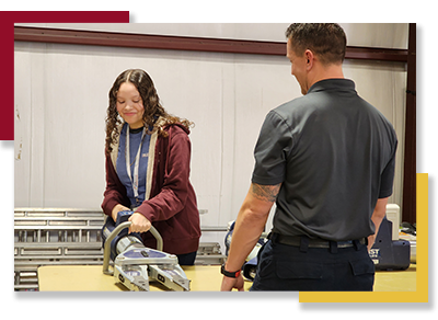 A GEAR UP student tries out firefighting equipment