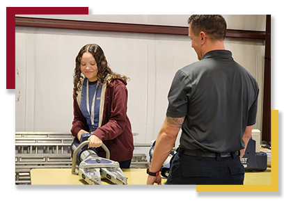 A GEAR UP student tries out firefighting equipment